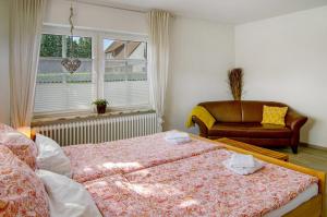 a bedroom with two beds and a couch and a window at Haus Scheve in Rhauderfehn