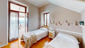 een slaapkamer met twee bedden en een groot raam bij Casale Massina APPARTAMENTO GIADA in Salò +26 foto's