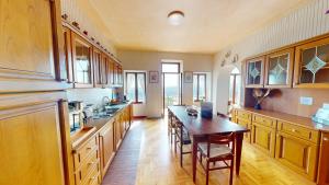 een grote keuken met een houten tafel en een houten vloer bij Casale Massina APPARTAMENTO GIADA in Salò