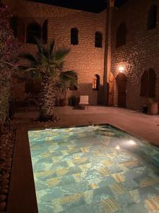 a large swimming pool in a courtyard at night at Villa lila in Essaouira