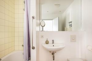 a white bathroom with a sink and a mirror at Miniloft Apartment Hotel in Berlin