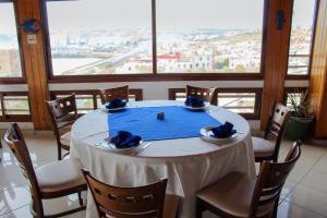 ein Tisch mit blauen Servietten und Stühlen in einem Zimmer in der Unterkunft Hôtel Riad Asfi in Safi