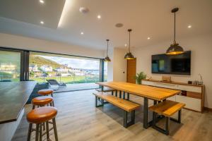 Un comedor con mesa y sillas y una gran ventana. en Combesgate House, en Mortehoe