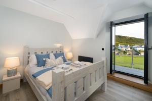 Un dormitorio con una cama grande y una ventana grande. en Combesgate House, en Mortehoe