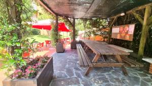 a wooden picnic table in a patio with flowers at Casa Carla in Peschiera del Garda