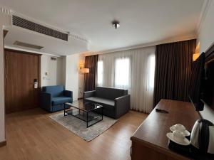 a living room with a couch and a chair and a table at İstanblu Hotel&Spa in Konak +32 photos