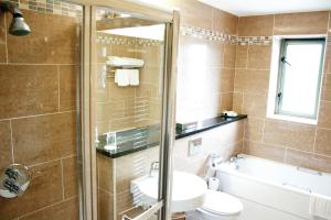 a bathroom with a shower and a sink and a toilet at Silverbirch Hotel in Omagh +15 photos