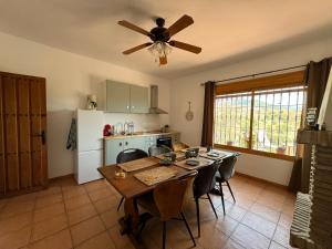 a kitchen with a dining room table and a ceiling fan at Casa Wenne - Private Pool with view in Sedella