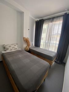 ミンデロにあるMorabezahomeのベッド2台と窓のある寝室