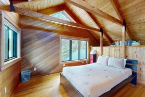 a bed in a room with a wooden ceiling at Serenity by the lake in Eden