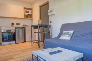 a living room with a blue couch and a table at Studio Miloé secteur TMB in Saint-Gervais-les-Bains +5 photos