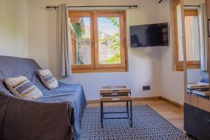 a living room with a couch and a window at Studio Miloé secteur TMB in Saint-Gervais-les-Bains
