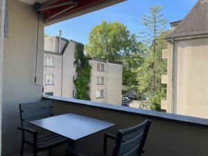 einen Tisch und Stühle auf einem Balkon mit Blick auf ein Gebäude in der Unterkunft Bright and practical Studio - Art 16 in Zürich