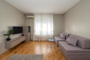 un soggiorno con un divano e una TV di Garni Hotel Mediteraneo a Novi Sad Altre 26 foto