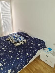 a bed with a blue comforter with stars on it at Villa Kale Luxury in Skopje