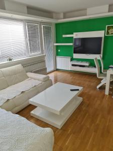 a living room with a white couch and a tv at Villa Kale Luxury in Skopje