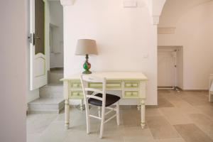 een bureau met een lamp en een stoel in een kamer bij Giona's guest house by IL PUMO DI PUGLIA in Martina Franca