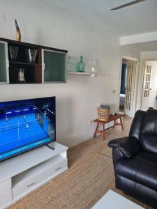 TV a/nebo společenská místnost v ubytování Nice and cozy flat with pool next to the beach
