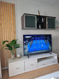TV a/nebo společenská místnost v ubytování Nice and cozy flat with pool next to the beach