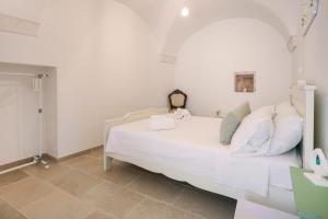een slaapkamer met een wit bed in een kamer bij Giona's guest house by IL PUMO DI PUGLIA in Martina Franca