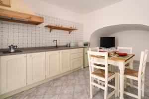 een keuken met witte kasten en een tafel en stoelen bij Giona's guest house by IL PUMO DI PUGLIA in Martina Franca +11 foto's