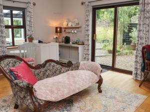 a living room with a chair with a red pillow at Pink Granite Garden of Ireland in Killicreny Bridge