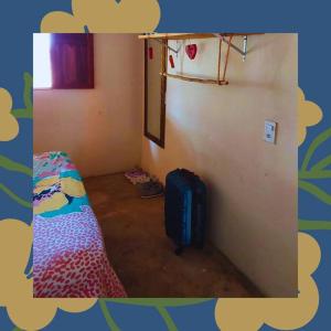 カライーバにあるCasa Marianaのベッドとスーツケース付きの小さな部屋です。