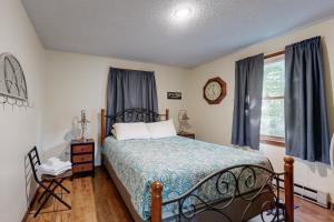a bedroom with a bed and a clock on the wall at Whispering Brook Townhouse in Bartlett