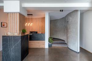 a lobby with a stone wall and a counter at Garni Hotel Mediteraneo in Novi Sad