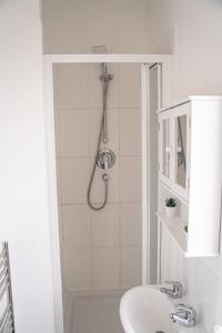 a white bathroom with a shower and a sink at Stylish Swindon Town Centre Apartment, FREE parking, sleeps up to 3 in Swindon