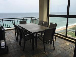 a table and chairs on a balcony with the ocean at 601 Bali Hai in Westbrook