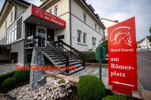 a building with a red sign in front of it at Hotel am Römerplatz in Ulm