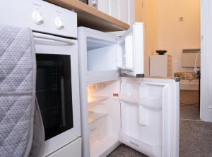 a white refrigerator with its door open in a room at Stylish Swindon Town Centre Apartment, FREE parking, sleeps up to 3 in Swindon +19 photos
