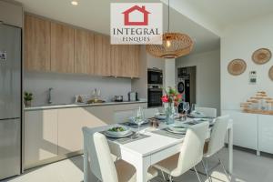 a kitchen and dining room with a white table and chairs at Apartament Mar Blau in Palamós