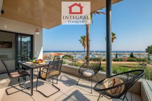 a balcony with a table and chairs and a view of the ocean at Apartament Mar Blau in Palamós