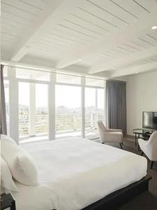 a bedroom with a large bed and a large window at Hollywood Hills Hotel in Los Angeles