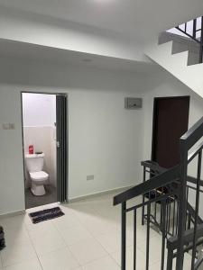 a bathroom with a toilet and a staircase in a room at Azzahra Homestay Scientex Kundang Jaya in Rawang