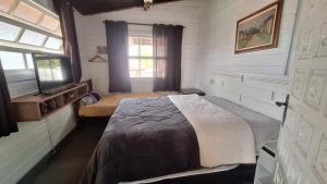 a bedroom with a bed and a window in it at Chácara Maira e Araken in Ibiúna +43 photos