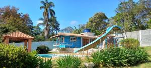 a house with a slide in front of a house at Chácara Maira e Araken in Ibiúna