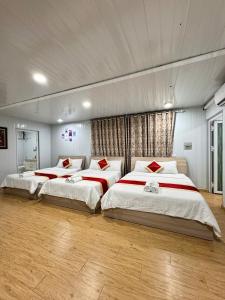 two beds in a large room with wood floors at Phúc Đạt Container in Vung Tau
