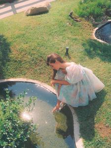 a girl in a dress sitting in a pool of water at Hollywood Hills Hotel in Los Angeles