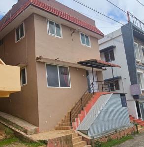 a house with a staircase in front of it at Stay awhile in Ooty