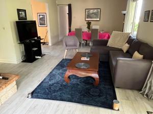 a living room with a couch and a table on a rug at Maison vacances Biarritz sud - plages à pied in Bidart
