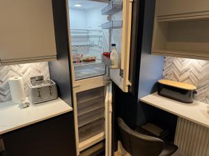 ein Kühlschrank mit offener Tür und einer Flasche Wein in der Unterkunft Cozy Apartment in Stoke-on-Trent One double bed in Stoke on Trent + 13 Fotos