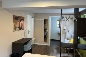 a room with a desk and a chair and a mirror at Pension No8 in Bad Vilbel