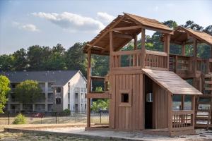 フォートブラッグにあるCb 204 Fayetteville Retreat, Free Parking, Poolの建物の前の大きな木製の遊具
