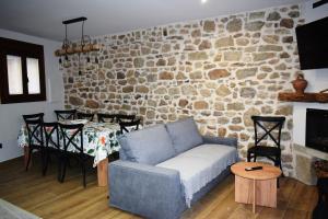 a living room with a couch and a stone wall at Alojamiento Rural La Josefa de los Arribes in Fermoselle