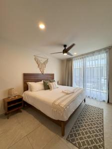 a bedroom with a large bed and a ceiling fan at Santal Tulum Condo Hotel By Marea in Tulum