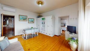 Una sala de estar con una mesa y un televisor. en Casale Massina APPARTAMENTO QUARZO, en Saló