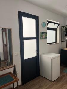 a room with a black door and a white refrigerator at Studio Casa Azul in San Andrés